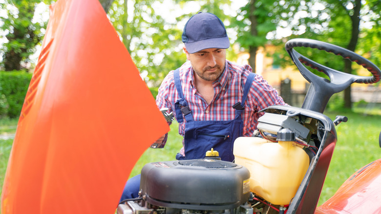 a man checking his lawn mower engine
