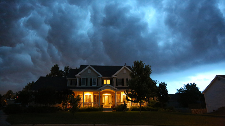 A large thunderhead over a house at night