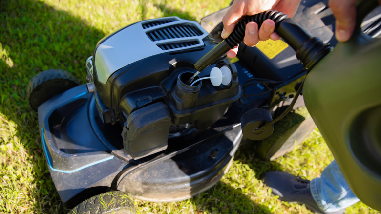 Person refueling a lawn mower