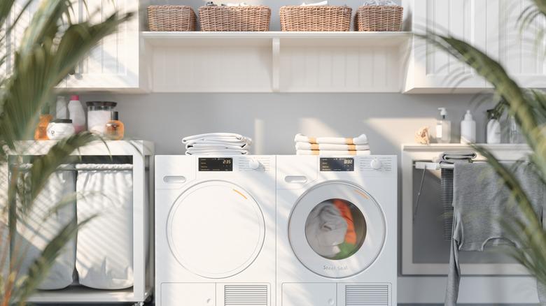 A very clean laundry room with white washer and dryer, wicker baskets, and laundry products.