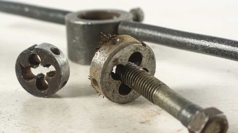 Using a die to re-cut threads into a bolt