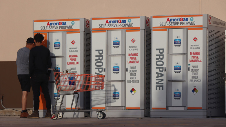 Two people exchanging a propane tank at an AmeriGas kiosk