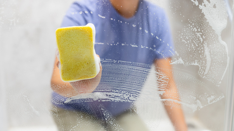 Person cleaning glass shower door