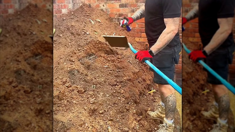 Person spraying WD-40 onto a shovel head