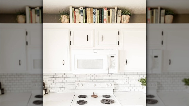 Books displayed above kitchen cabinets