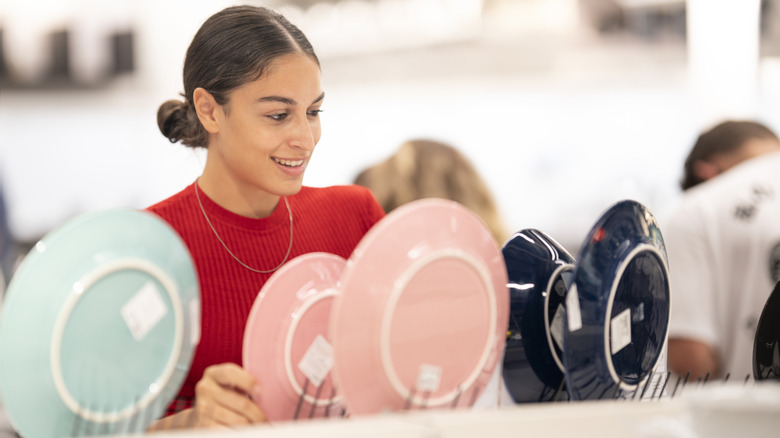 Woman standing in front of plates affixed onto holders