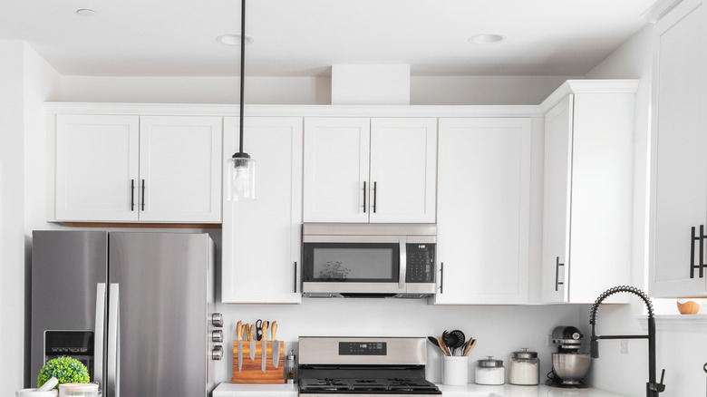 White kitchen cabinets with empty spaces on top of them