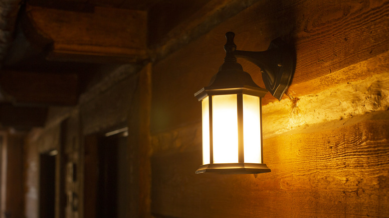 An outdoor light mounted to a wall emitting warm, yellow light