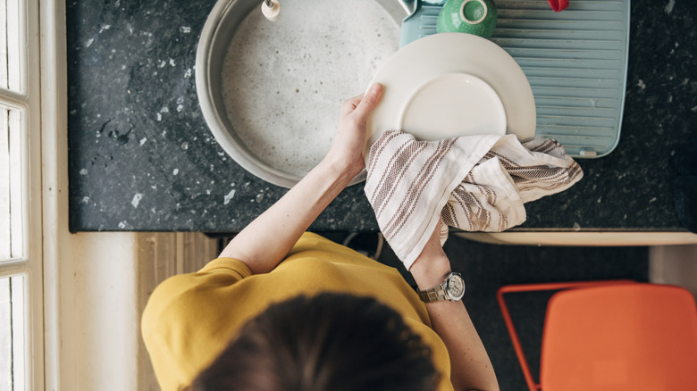 An overhead shot of a woman drying dishes