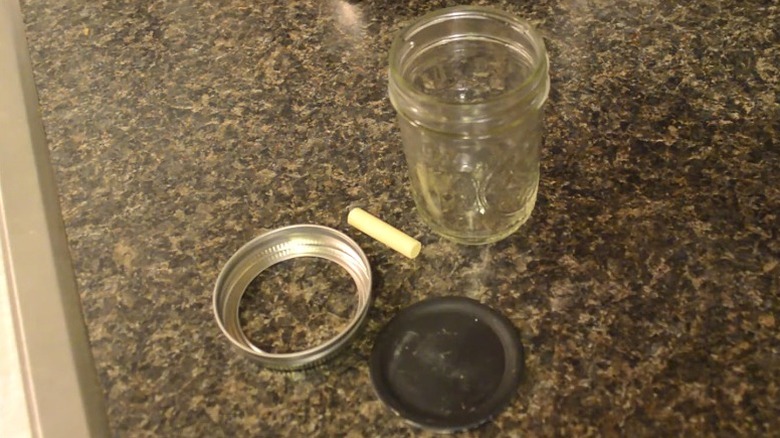 Chalkboard paint Mason jar lid with chalk and jar on kitchen counter