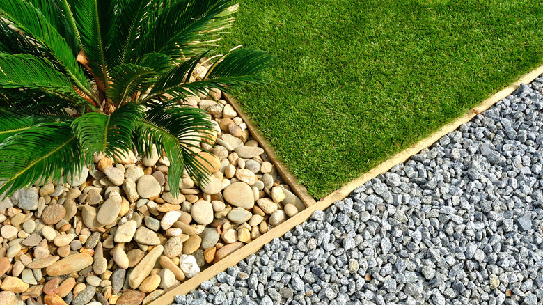 A yard with two different kinds of gravel hardscaping and a lawn.