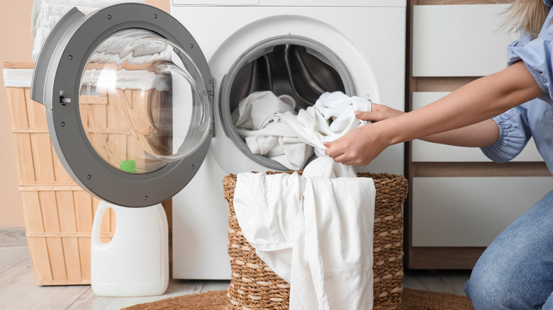 Person takes a load of white laundry out of the washing machine.