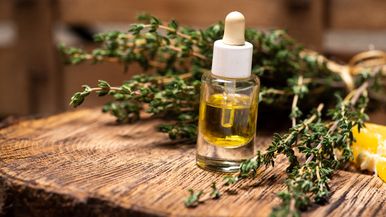 bottle of essential oil and thyme sprigs