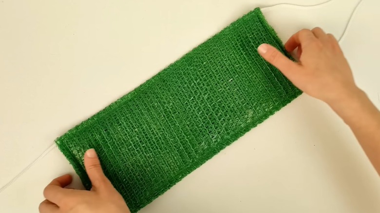 Hands holding homemade exfoliating cloth with handles