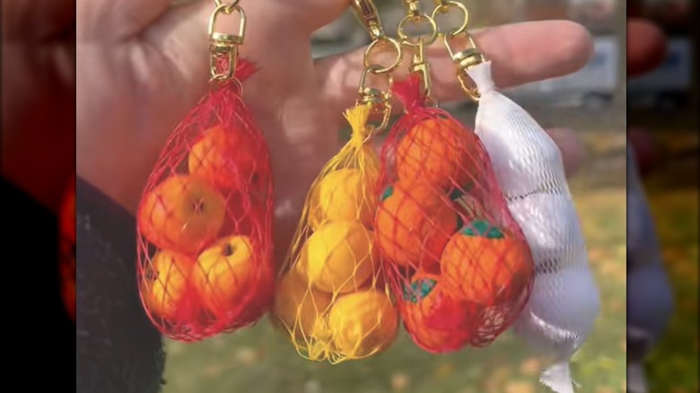 Homemade gold keychains made with mini plastic fruits and produce mesh