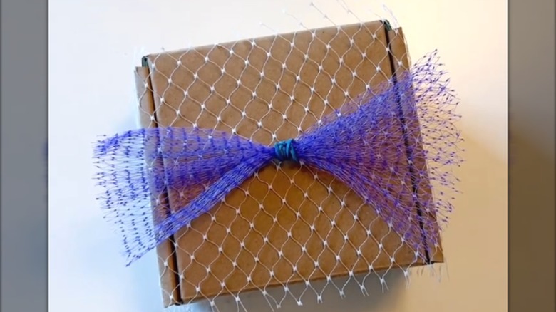 Purple produce mesh wrapped around mini cardboard gift box