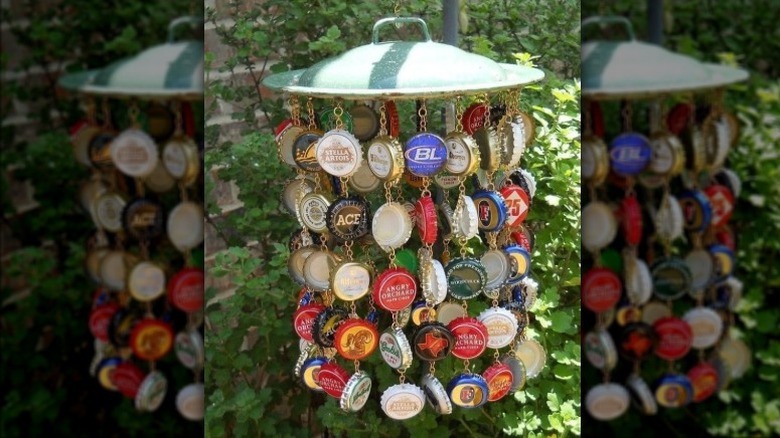 A windchime made from an old metal pot lid and strands of upycled beer bottle caps.