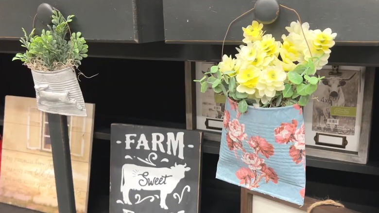 Flattened soup cans with wire hangers for indoor, artificial foliage decor
