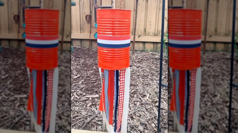 Festive red, white, and blue outdoor soup can streamer over mulch