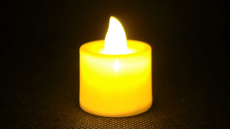 A flameless candle lit in a dark area