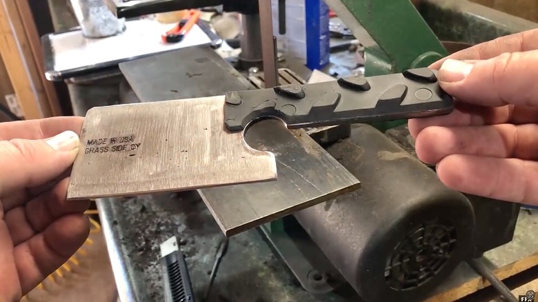 Man holding a small butcher knife made from an old lawn mower blade