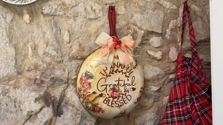 A decorated frying pan hanging in a cottage