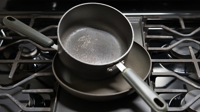 two old scratched pans on a stovetop