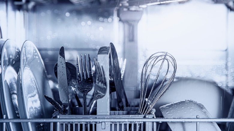 Various dishes inside a dishwasher during a cycle