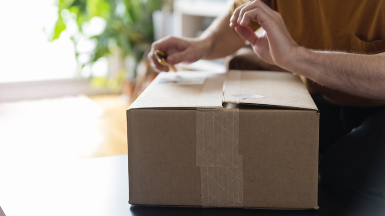 a man cuts open a cardboard box