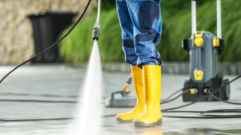 Person pressure washing concrete