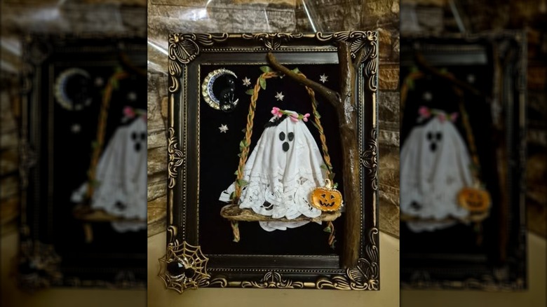 Ghost doily sitting on a swing with a moon in the background
