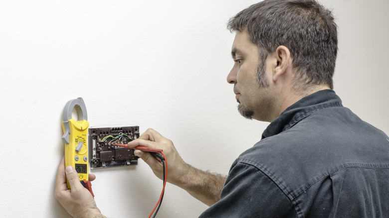 Technician checking the voltage on a thermostat