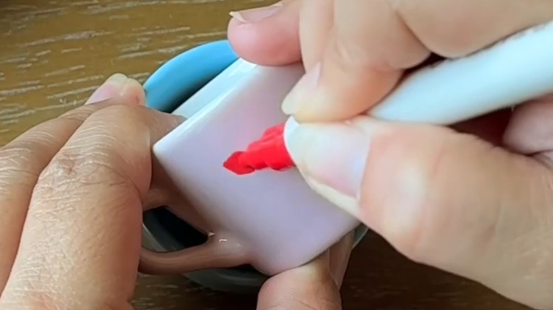 person painting pastel teacup