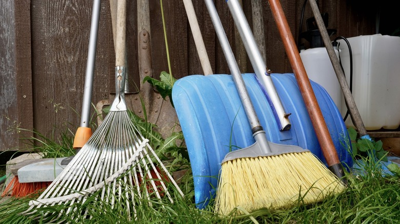 Garden tools stored outside leaning against a wall