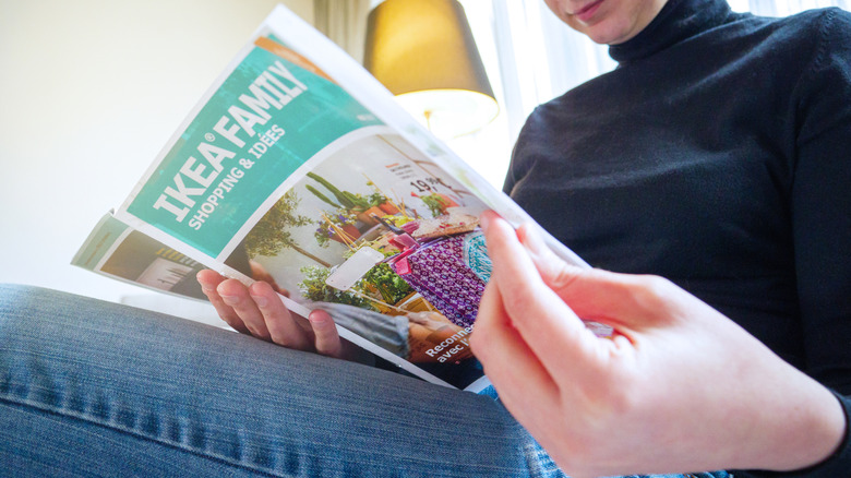 A person reading a vintage IKEA catalogue.