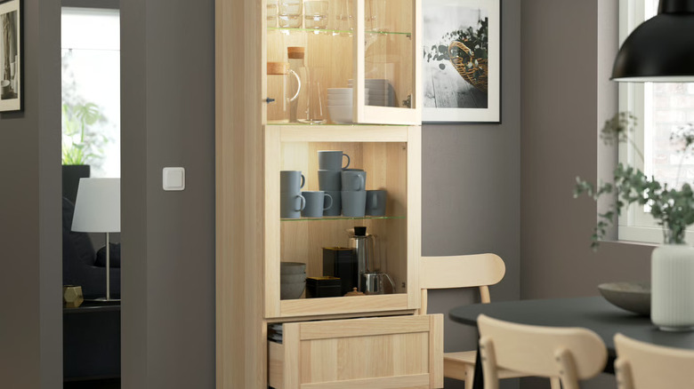 Glass-fronted shelving unit with coffee mugs
