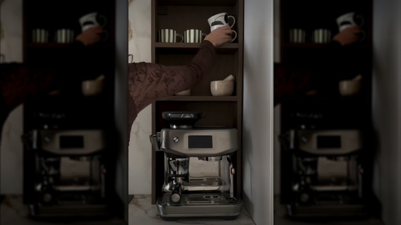 Person placing coffee mugs on a HAGAAN shelving unit converted to a coffee station