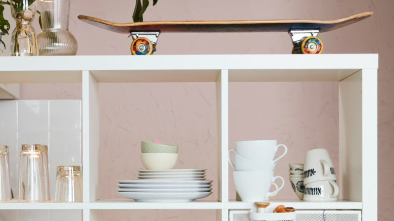 Coffee, tea cups, dishes, glass cups, and skateboard on a KALLAX unit