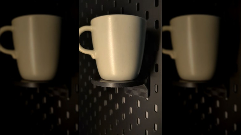 A coffee cup mounted to a SKADIS pegboard
