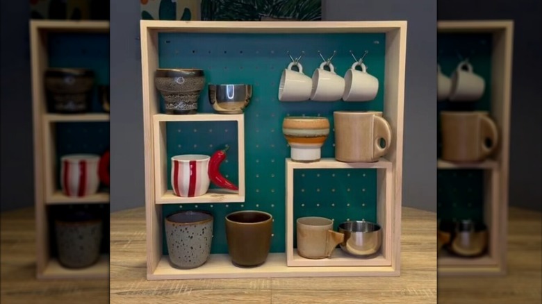 Coffee mugs hung on SKOGSMOSAIK display shelf