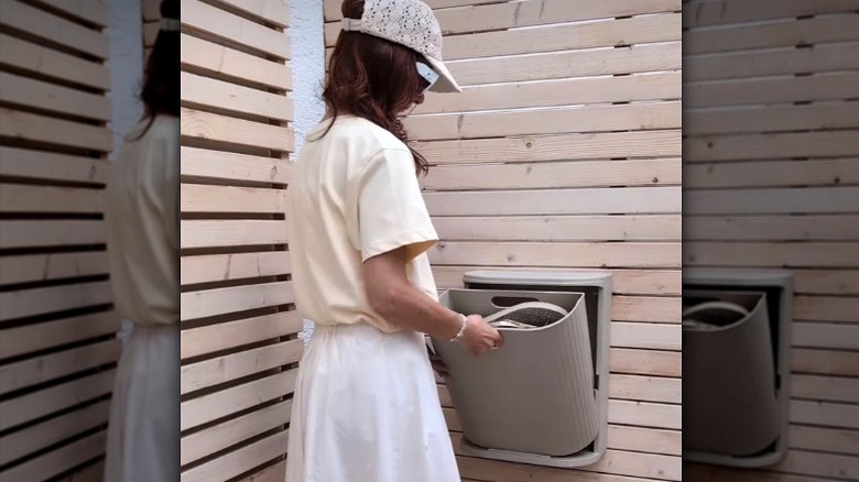 Woman putting shoes in IKEA GÅRDSBUTIK for outdoor storage