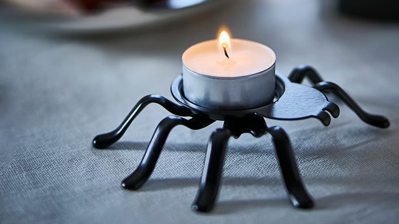 A lit tealight on the back of a black spider