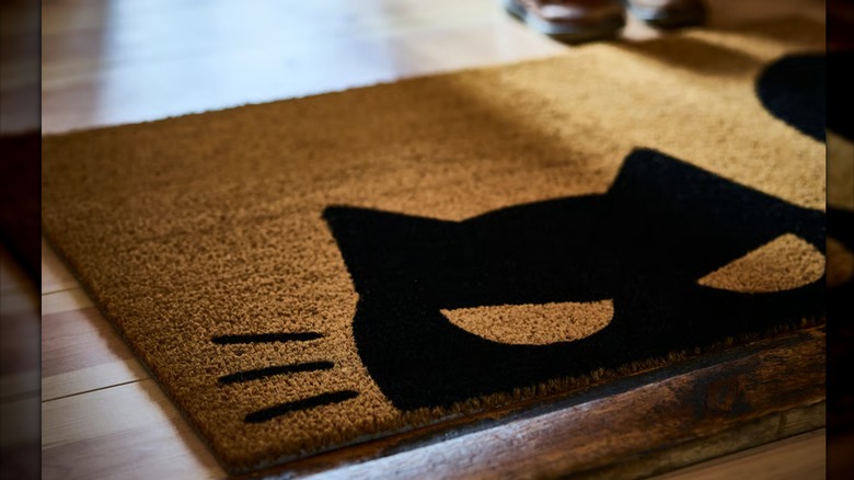 A cat-themed door mat placed in a home's entryway