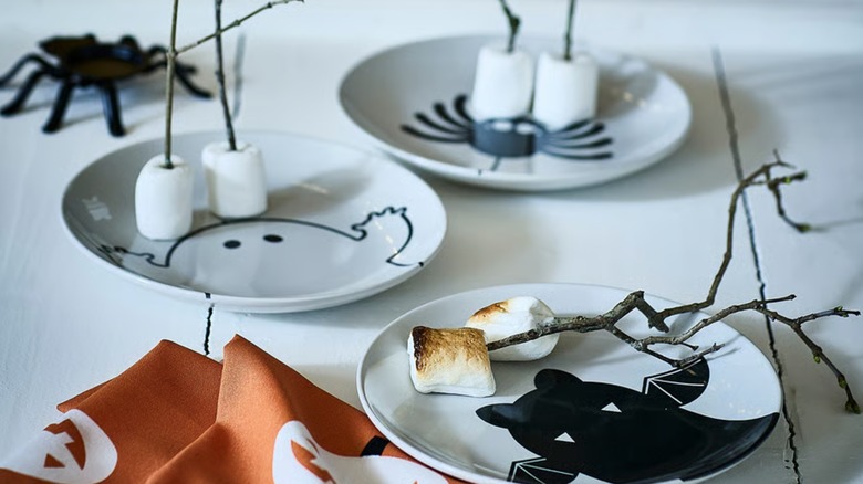 Three Halloween-themed small side plates with marshmallows on them