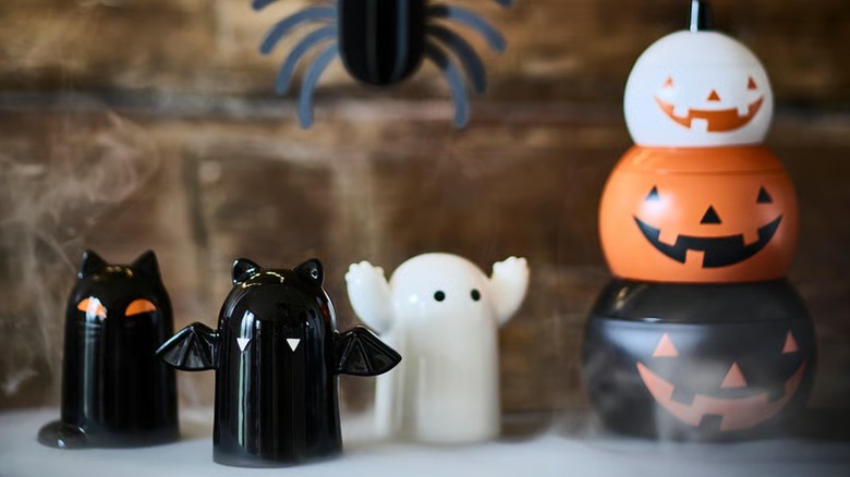 Three glazed earthenware decor pieces in a room decorated for Halloween