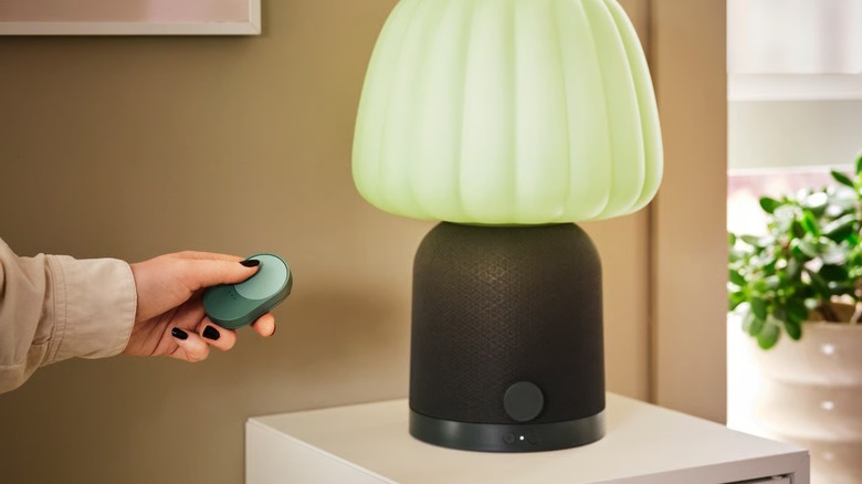 Person holding the IKEA remote near a lamp