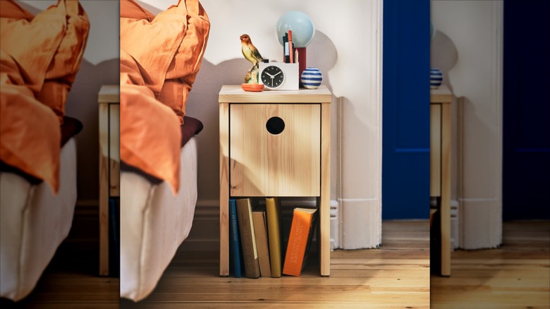 IKEA PS 2026 Nightstand next to bed with books and bedroom clutter
