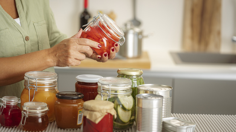 A person sorting jars and canned goods