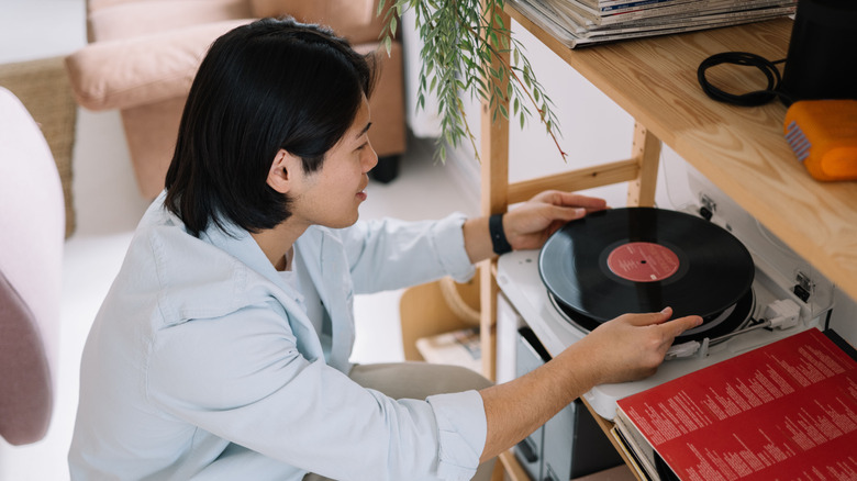 Man places a record on a record player