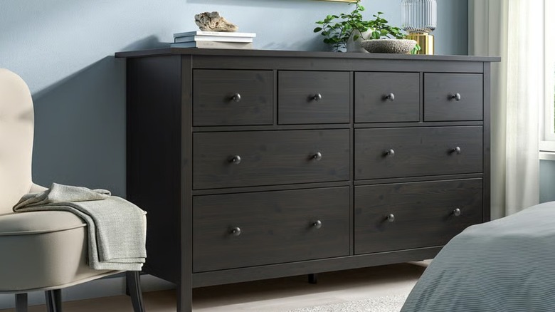 A dark brown stained dresser drawer in a bedroom